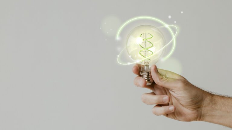 Mão segurando lâmpada iluminada com DNA verde e efeitos digitais, representando inovação científica e novas chamadas públicas da Finep/MCTI