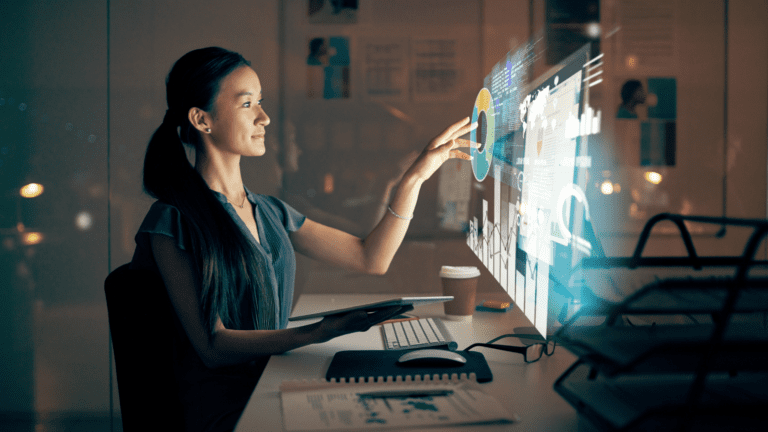Mulher utilizando tela interativa digital em ambiente corporativo, representando fortalecimento do setor brasileiro de softwares com parceria entre EMBRAPII e ABES.