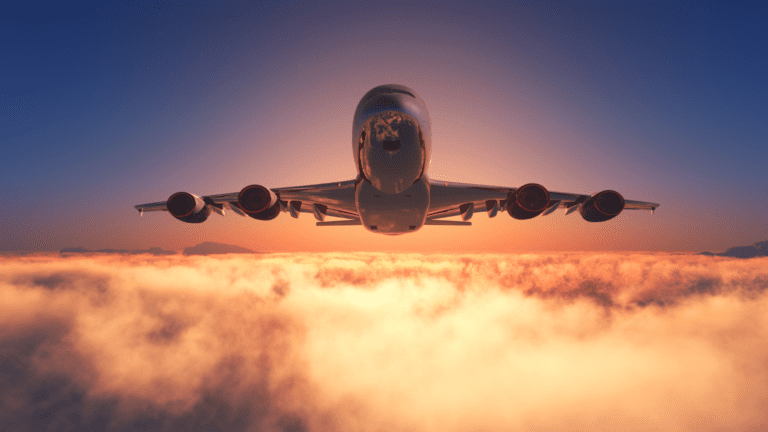 Avião voando sobre nuvens ao pôr do sol, simbolizando pesquisas em transporte sustentável de longa distância apoiadas pela FAPESP.