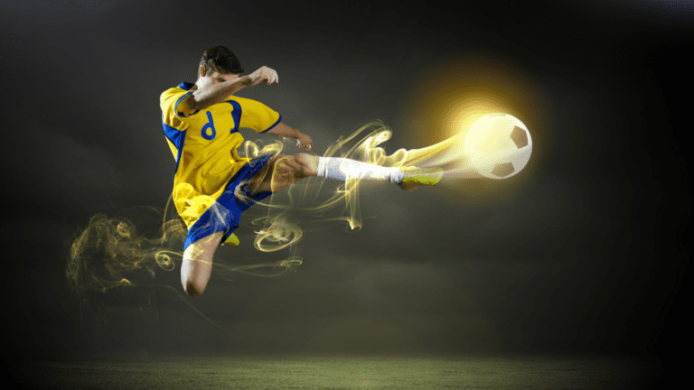 Jogador de futebol com uniforme amarelo chutando bola iluminada, simbolizando como a inovação no esporte inspira o mundo corporativo.
