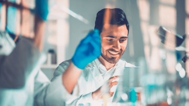 Pesquisador sorridente em laboratório, representando parceria da FAPESP com o European Research Council em nova chamada científica.