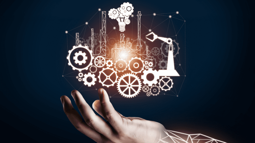 Mão sustenta rede de engrenagens, fábrica e braço robótico iluminados, simbolizando a cooperação Brasil-Canadá para inovação industrial e manufatura avançada.