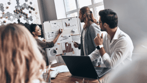 Equipe de inovação realiza assessment com gráficos e indicadores em quadro branco durante reunião corporativa