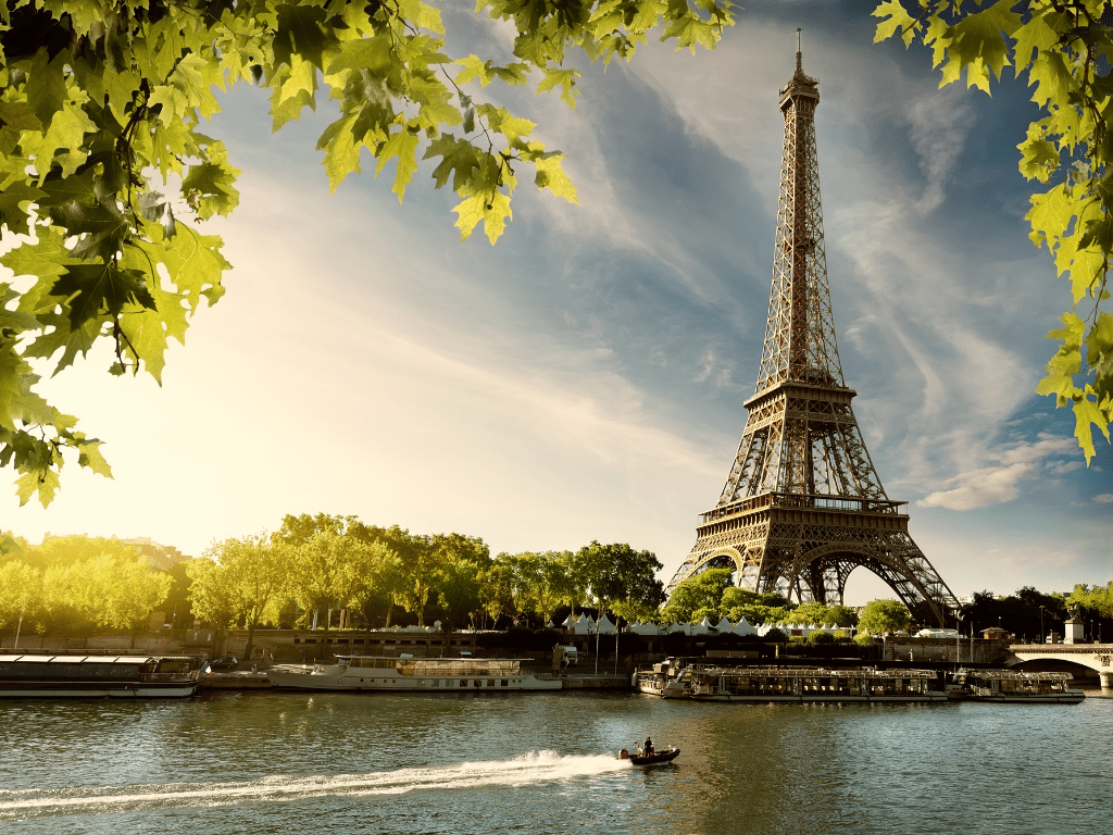 Torre Eiffel em Paris, França, vista entre árvores verdes em um dia ensolarado