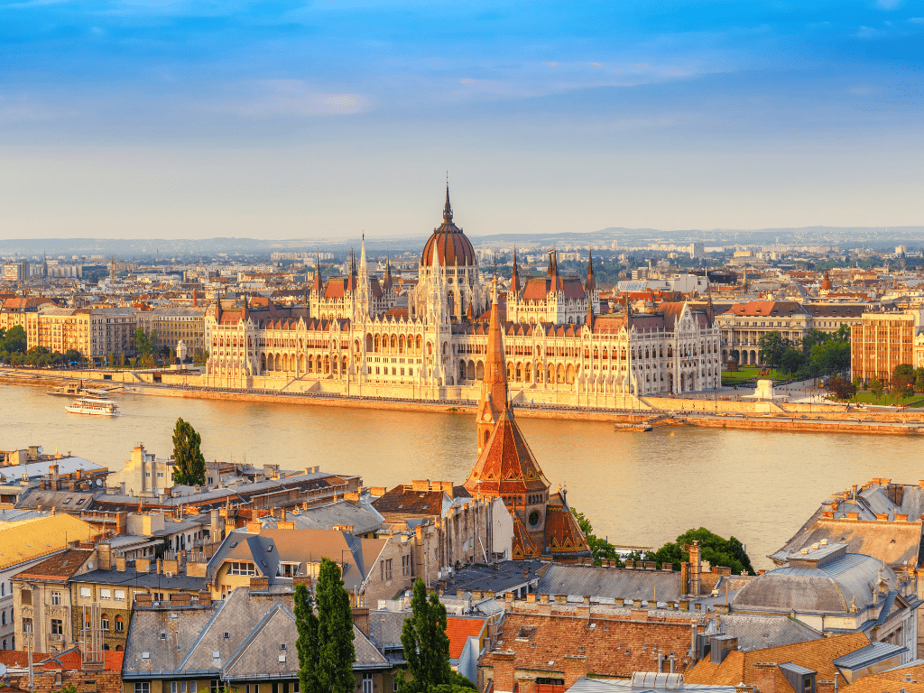 Vista panorâmica do Parlamento Húngaro em Budapeste, Hungria, às margens do rio Danúbio ao pôr do sol.