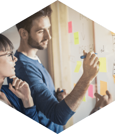 Profissionais colaborando em um quadro com post-its coloridos, simbolizando brainstorming e geração de ideias inovadoras.