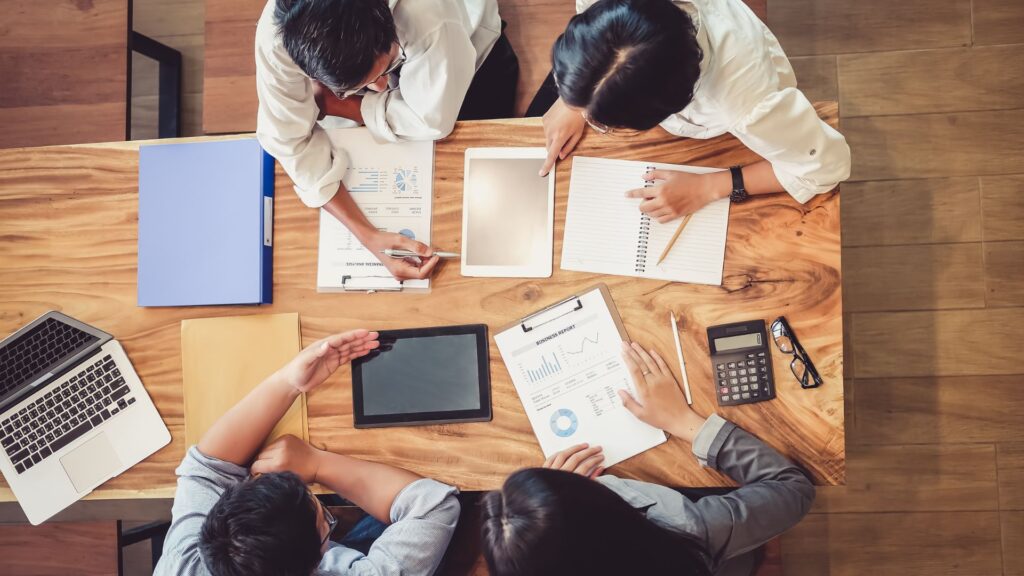 Equipe analisando relatórios, tablet e calculadora sobre a mesa — MCTI lança novo FormP&D para projetos de empresas da Lei do Bem.
