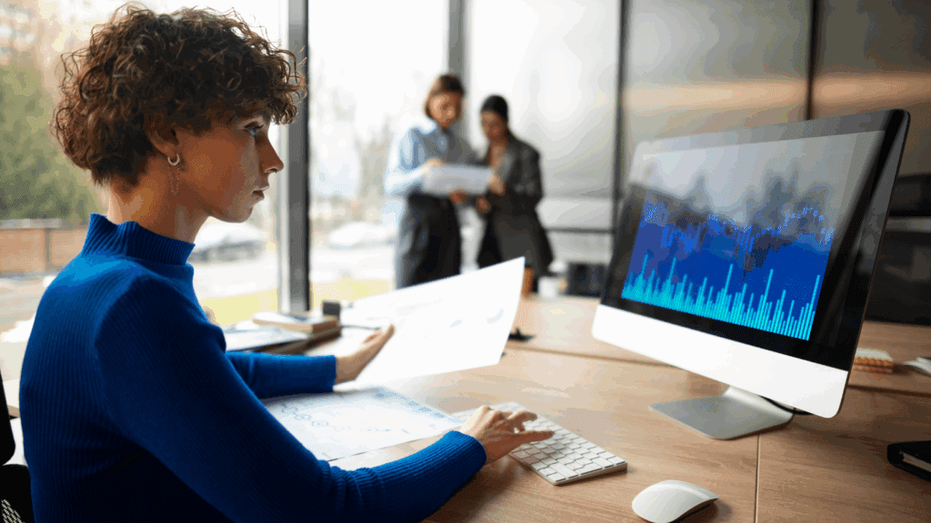 Analista confere relatório e gráficos em monitor para otimizar incentivos fiscais da Lei do Bem.