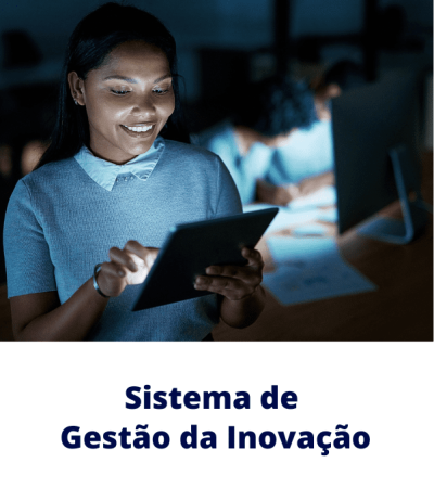 Profissional sorri enquanto usa um tablet em escritório colaborativo — Sistema de Gestão da Inovação e transformação digital nas empresas.